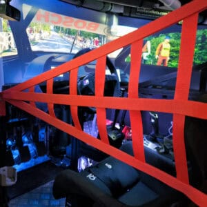 Red sim racing safety net mounted on the side of a cockpit